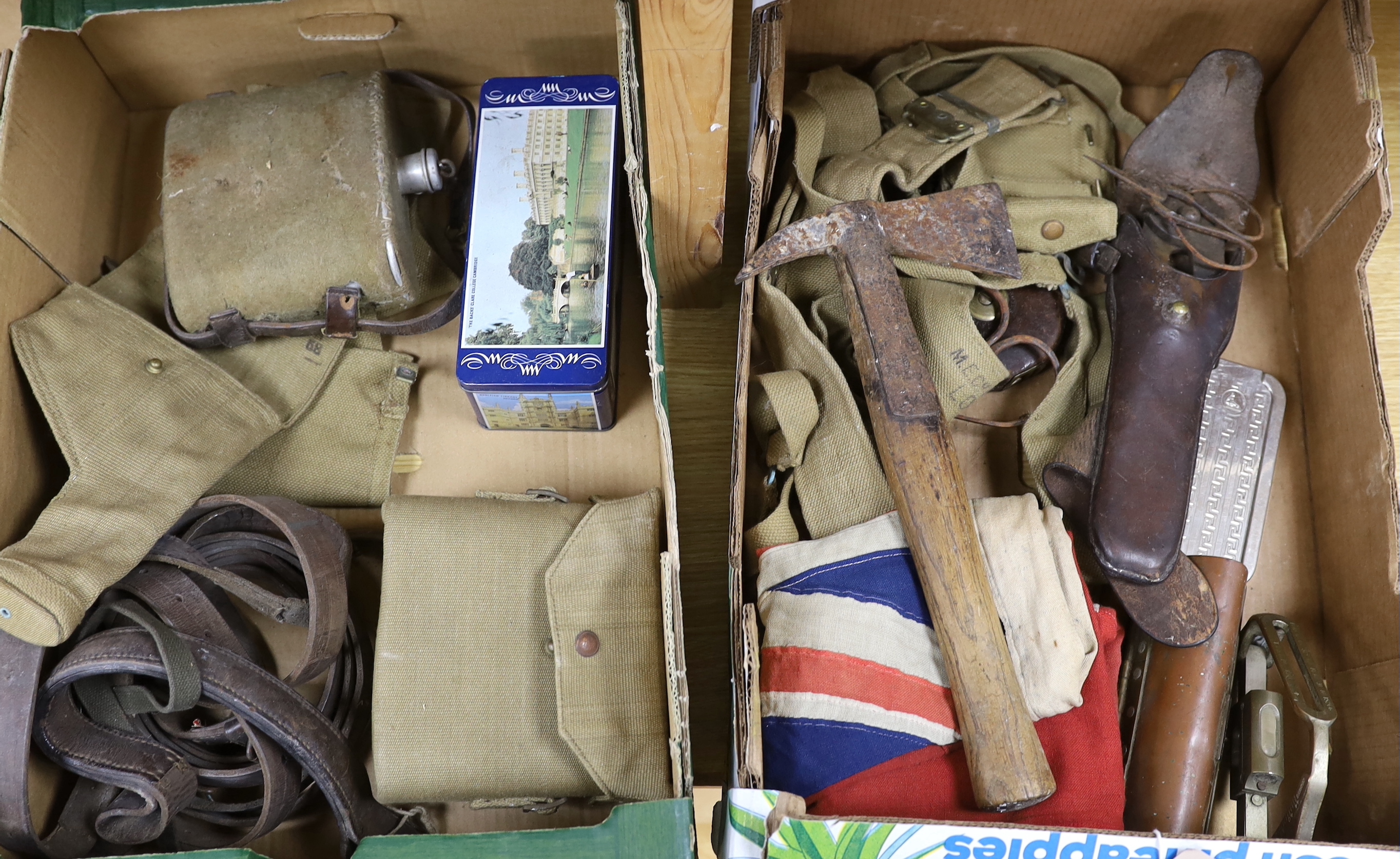 A collection of militaria including a union flag, gunners sight, camouflage webbing, a water bottle, an axe, a bosun’s whistle, and other items